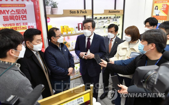 이낙연 더불어민주당 대표(가운데)가 지난 14일 코로나19 이익공유제 실현 현장 방문의 일환으로 서울 영등포 지하상가 내 네이처컬렉션을 찾아 정기화 가맹점주(왼쪽 세 번째)의 얘기를 듣고 있다. 연합뉴스.